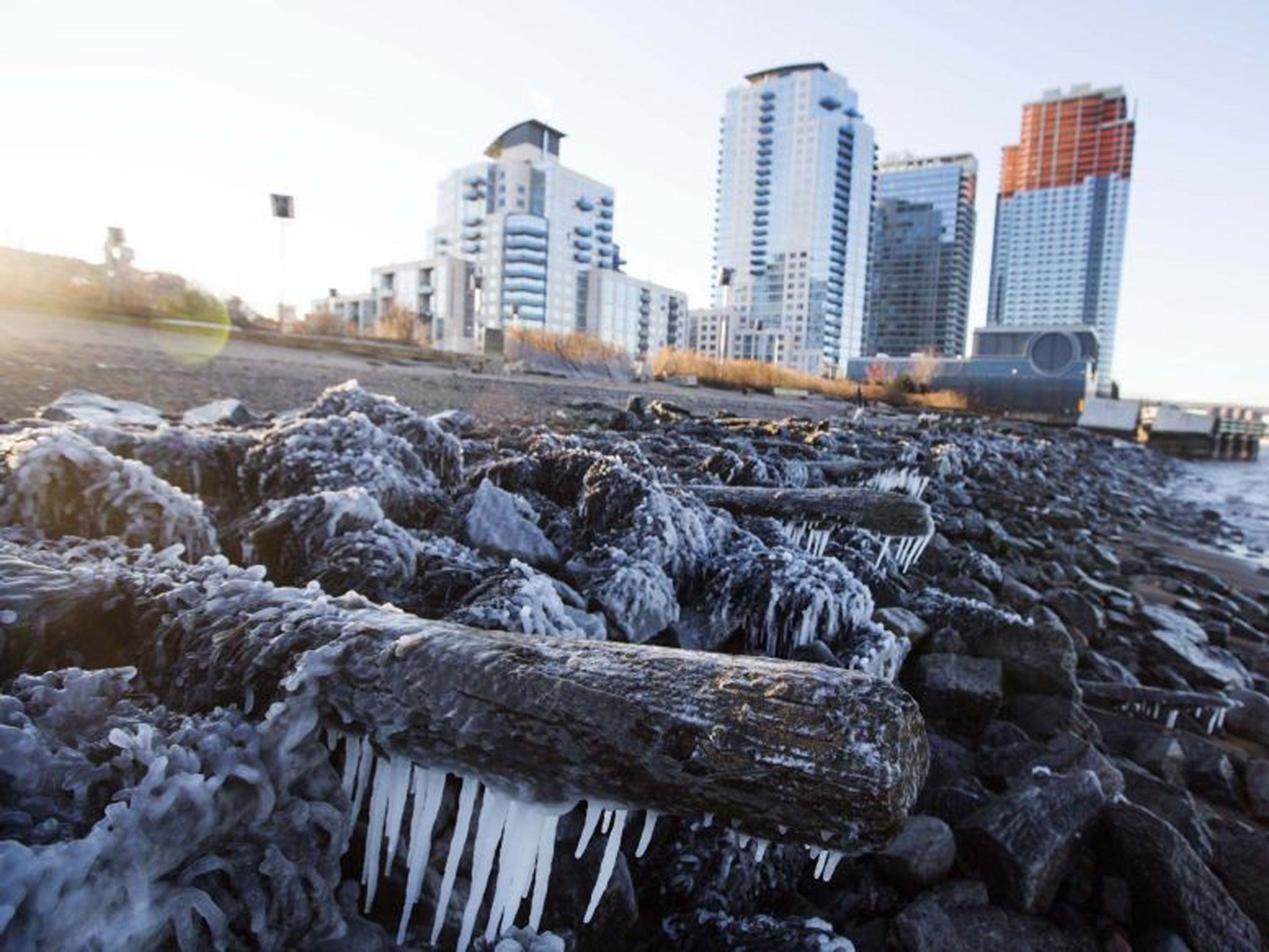 Ice forms on the shore of the East River due to unusually low temperatures caused by a polar vortex in New York