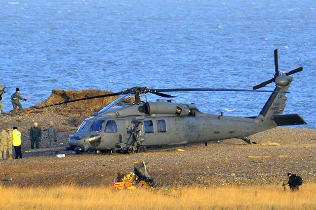 A Pave Hawk helicopter, military personnel and emergency services attend the scene of the crash on the coast near Cley