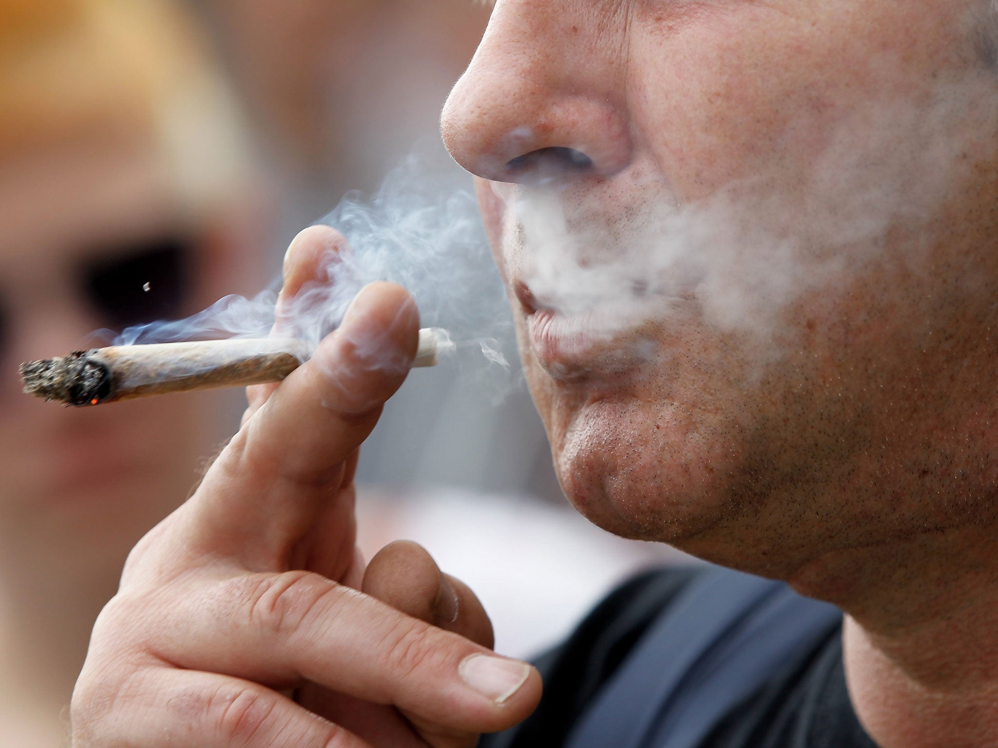 A man smokes a joint containing marijuana.