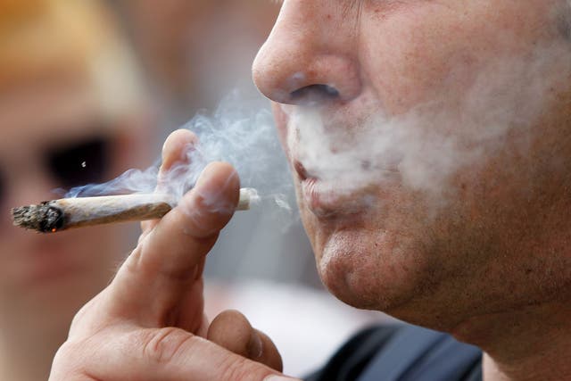 A man smokes a joint containing marijuana. 