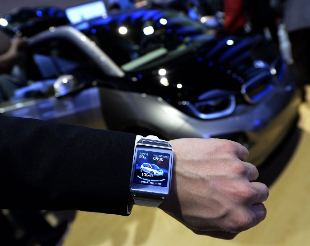 The Samsung Galaxy Gear smart watch is shown displaying a BMW app.