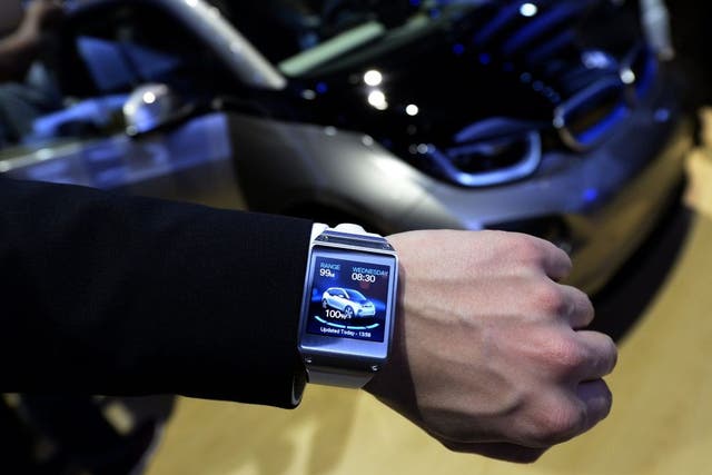 The Samsung Galaxy Gear smart watch is shown displaying a BMW app.