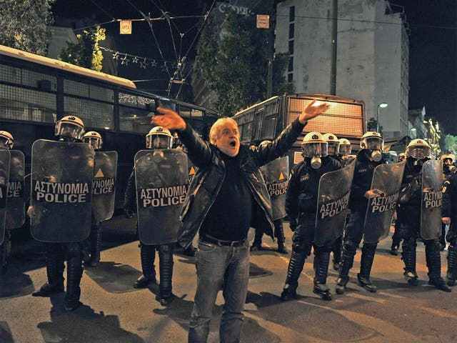 Police surround a protester as tight security was rolled out in Athens, ahead of the official opening ceremony for the Greek EU presidency, with official protests banned