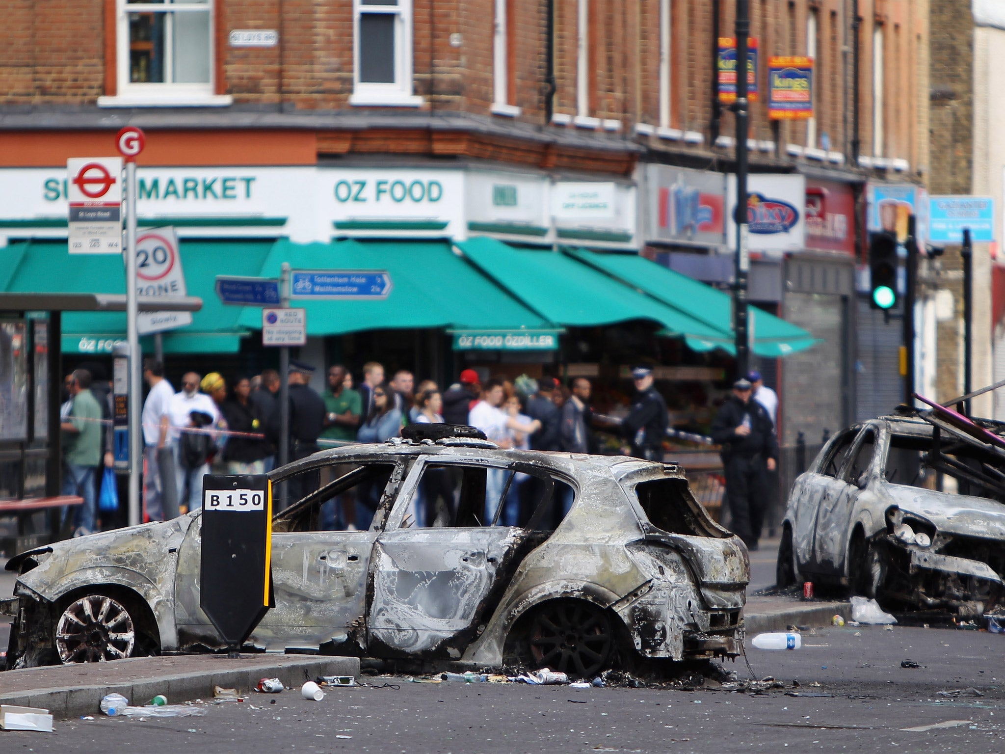 Burnt out cars lie in the road after riots on Tottenham High Road on August 7, 2011