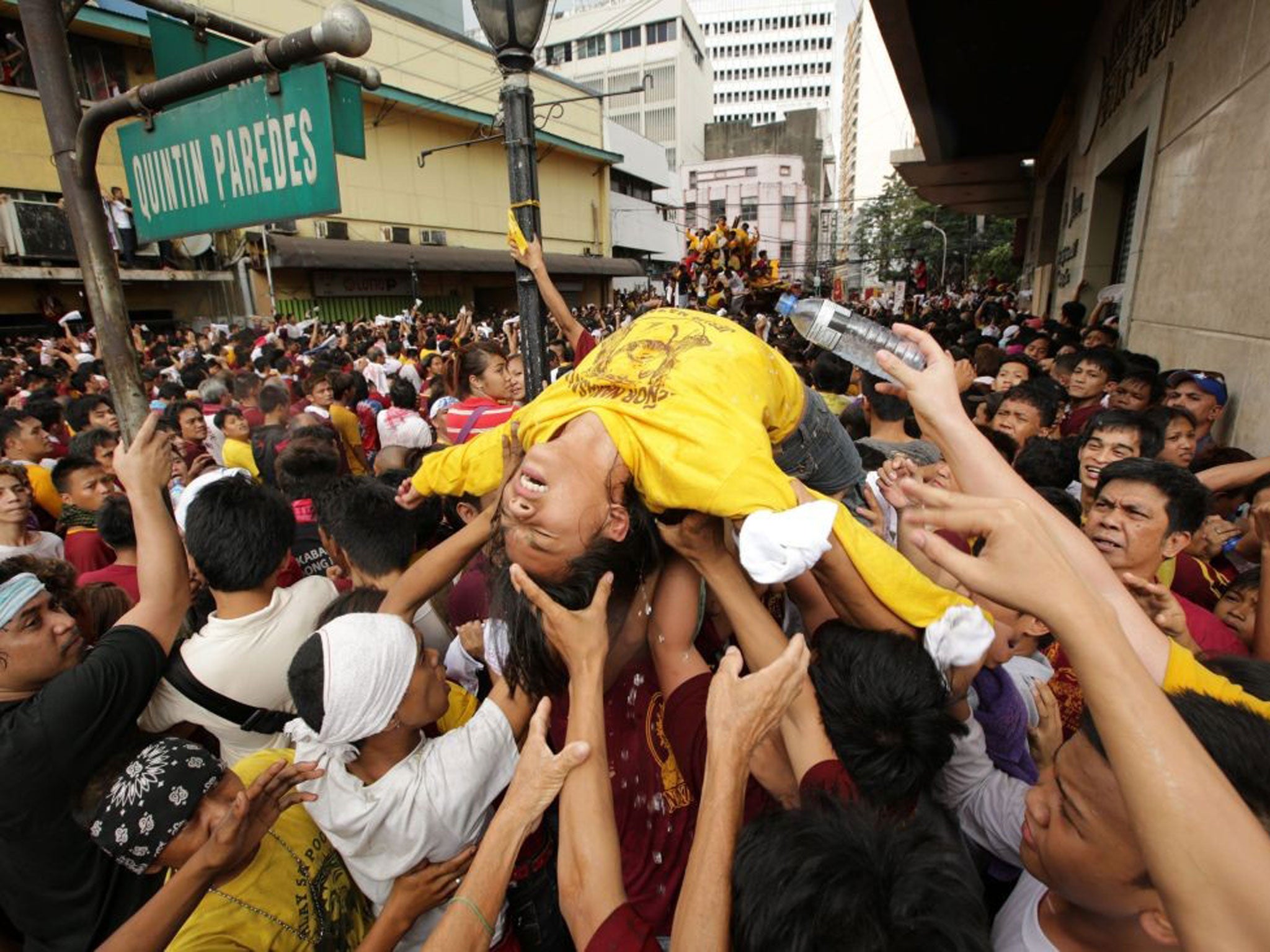 Filipino devotees carry an unconscious woman during the Black Nazarene procession in Manila. The procession jammed thoroughfares in the capital, and nearly 584 people were brought to first aid stations for treatment for cuts on their feet, dizziness and h
