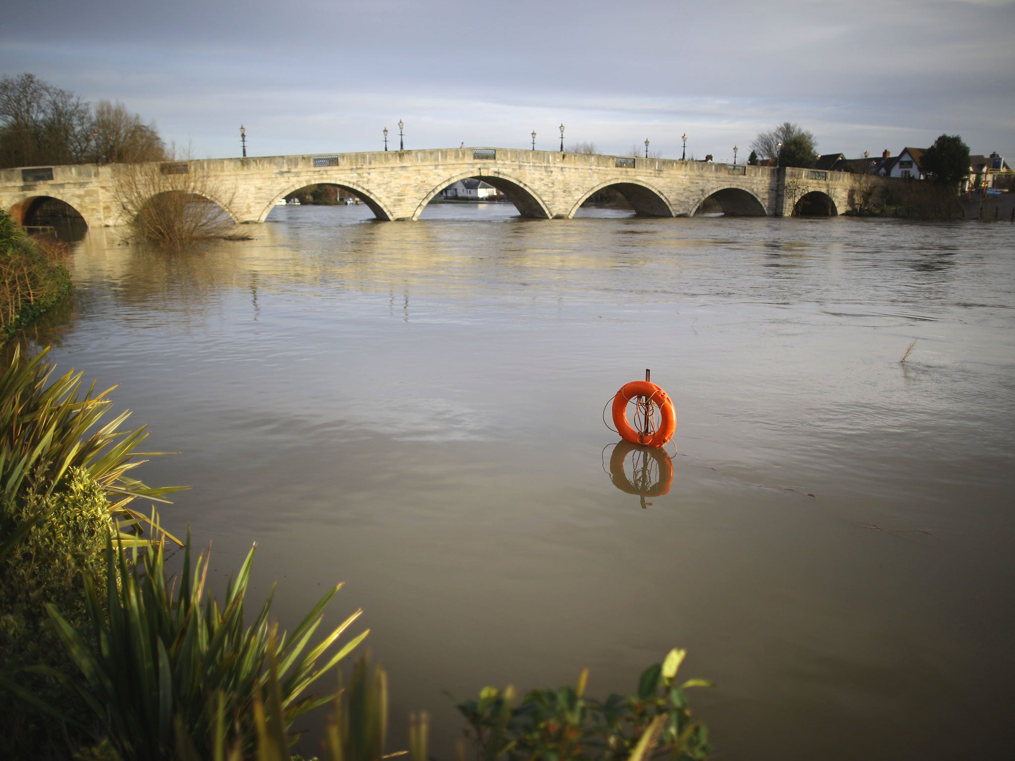 A lifebelt is almost submerged after the River Thames flooded in Chersey
