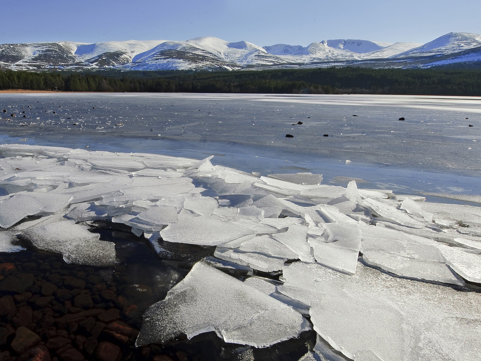 Frozen shore of Loch Morlich and the Cairngorm Mountains in the Glenmore Highlands