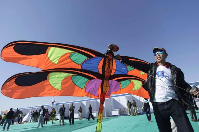 A man from Malaysia prepares to fly a kite during the International Kite Festival at white sand in the Rann of Kutch, a seasonal salt marsh located in the Thar Desert, in Dhordo, about 500 kilometers (311 miles) from Ahmadabad