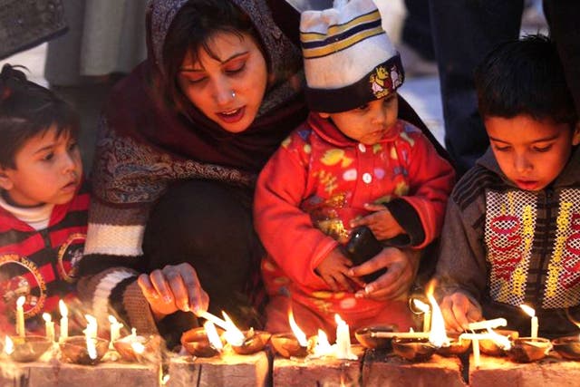 Pakistani Muslim devotees light candles while visiting the shrine of Saint Mian Mir Sahib, during an event marking the 369th death anniversary of the saint in Lahore