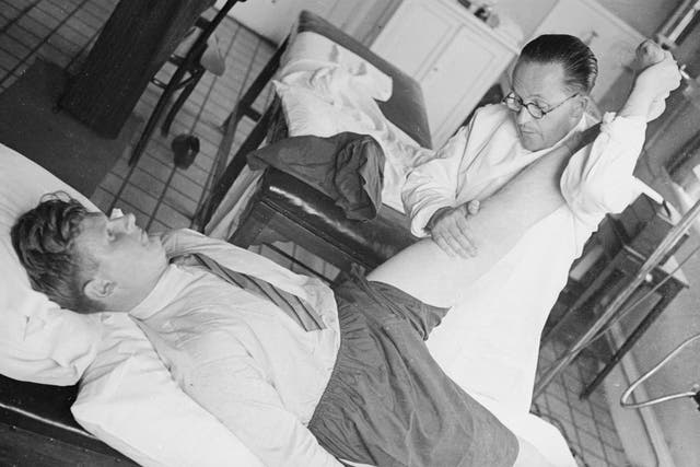 An osteopath manipulates a patient's joints at the British School of Osteopathy in London, in 1940