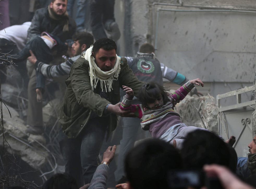 Men help a wounded girl who survived what activists say was an airstrike by forces loyal to President Bashar al-Assad in the Douma area of Damascus earlier this week