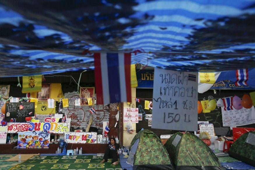 A man rests in the anti-government protesters' encampment near the Democracy monument in Bangkok