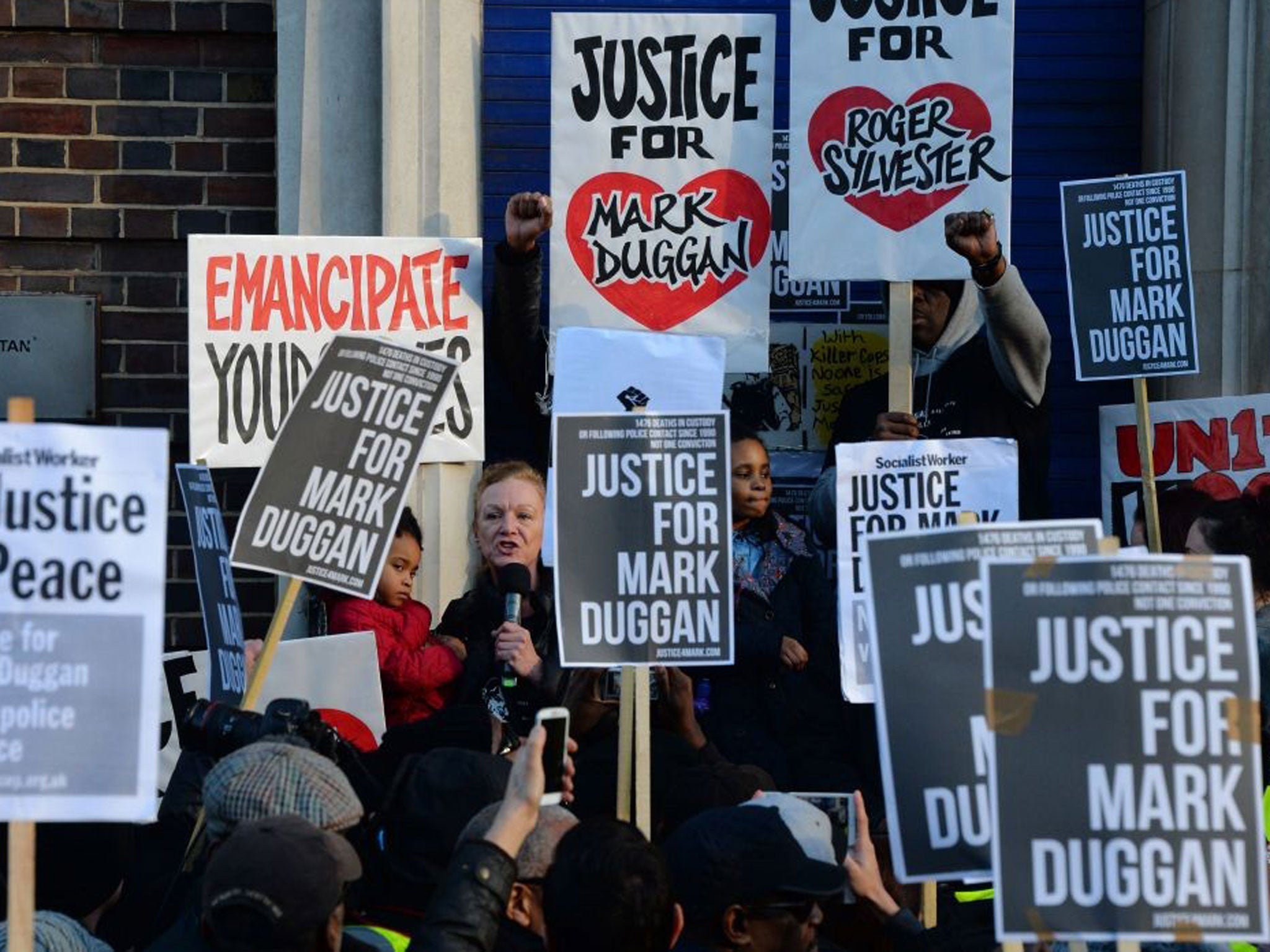Carole Duggan (L), aunt of Mark Duggan who was shot dead by police, addresses the gathering outside Tottenham Police Station in London on 11 January, 2014,