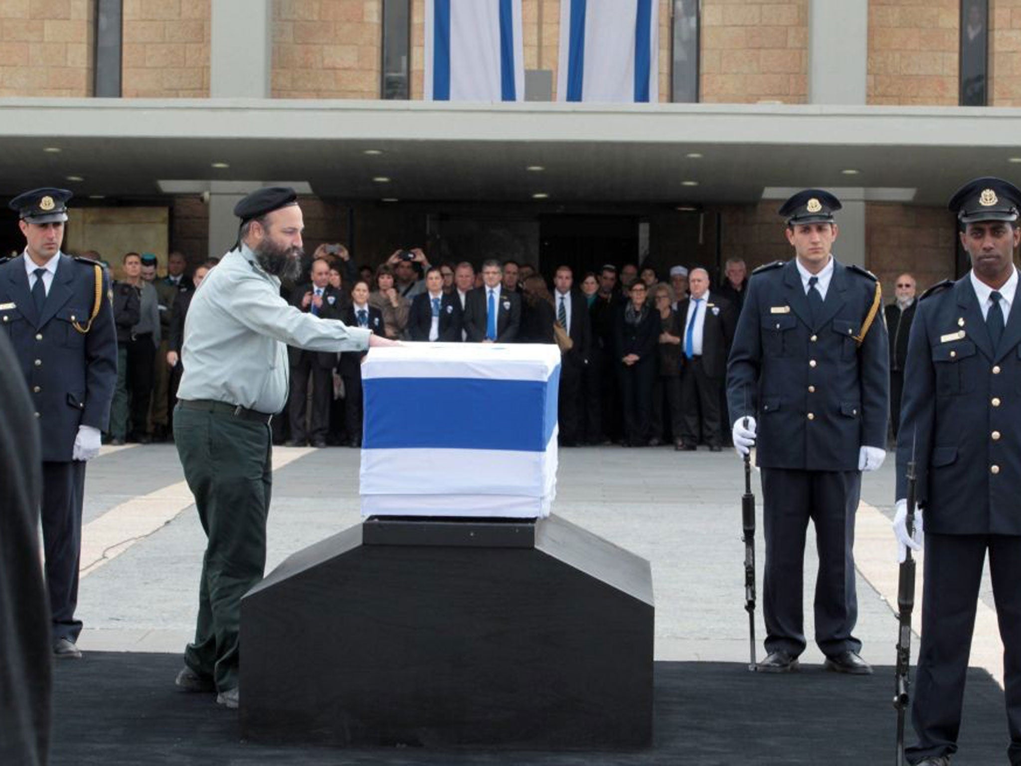 An Israeli military rabbi touches the coffin of former prime minister Ariel Sharon outside the Knesset