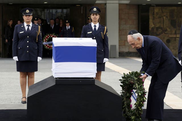 Israel’s President Shimon Peres lays a wreath at the coffin of the former Prime Minister in Knesset Plaza, Jerusalem