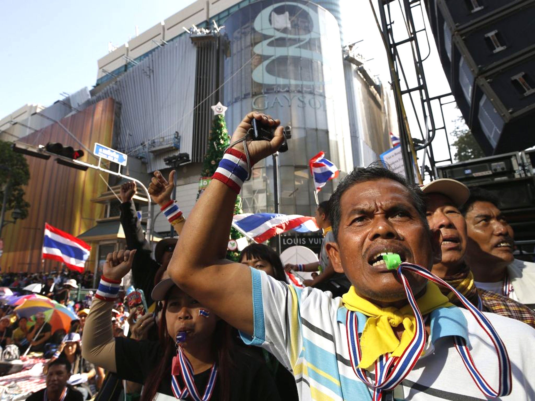 Anti-government protesters blow whistles and shout slogans as they blocking a main road during the 'Bangkok Shutdown' campaign rally at Ratchaprasong shopping district in central of Bangkok