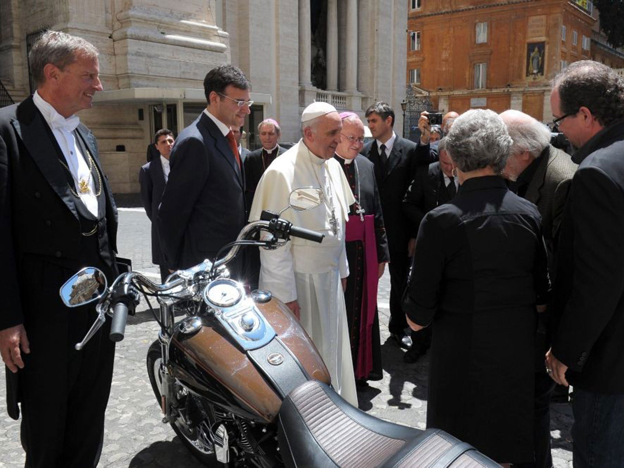 Pope Francis being presented with a Harley Davidson Dyna Super Glide motorcycle in Vatican