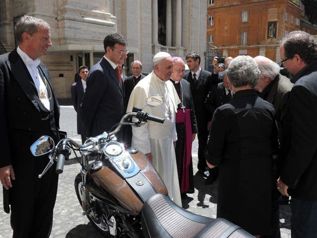 Pope Francis being presented with a Harley Davidson motorcycle in the Vatican last year.