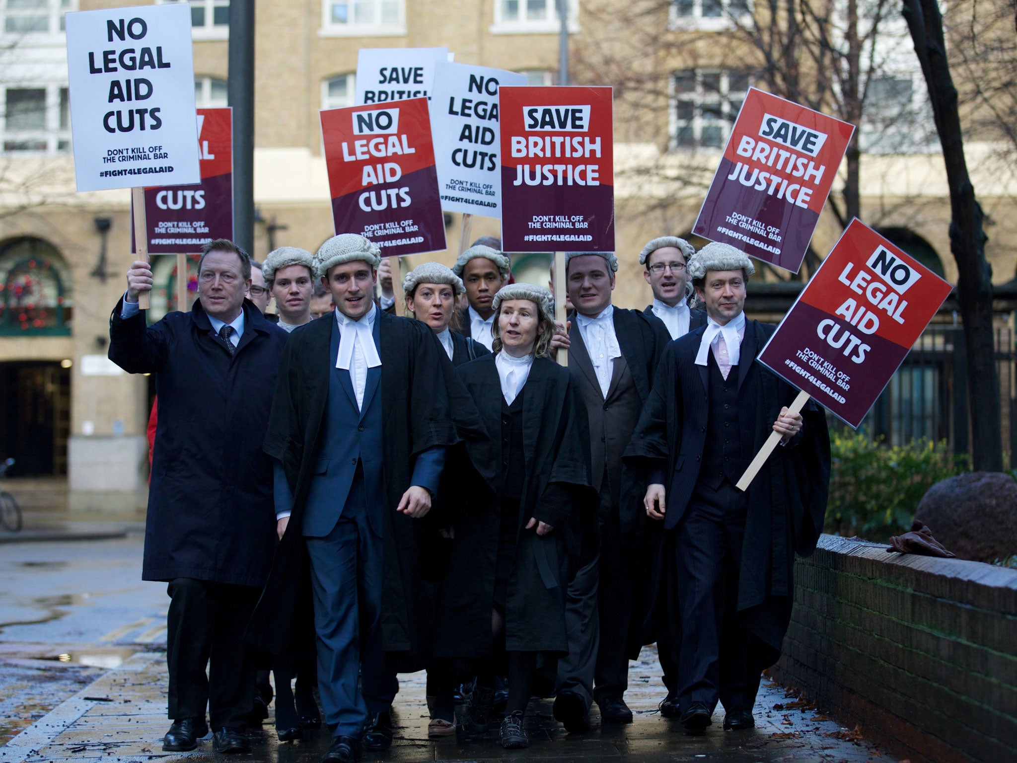 Legal professionals hold placards during a protest against cuts to the legal aid budget on 6 January. The number of separating couples accessing publicly funded mediation or family lawyers have fallen dramatically due to the changes to legal aid