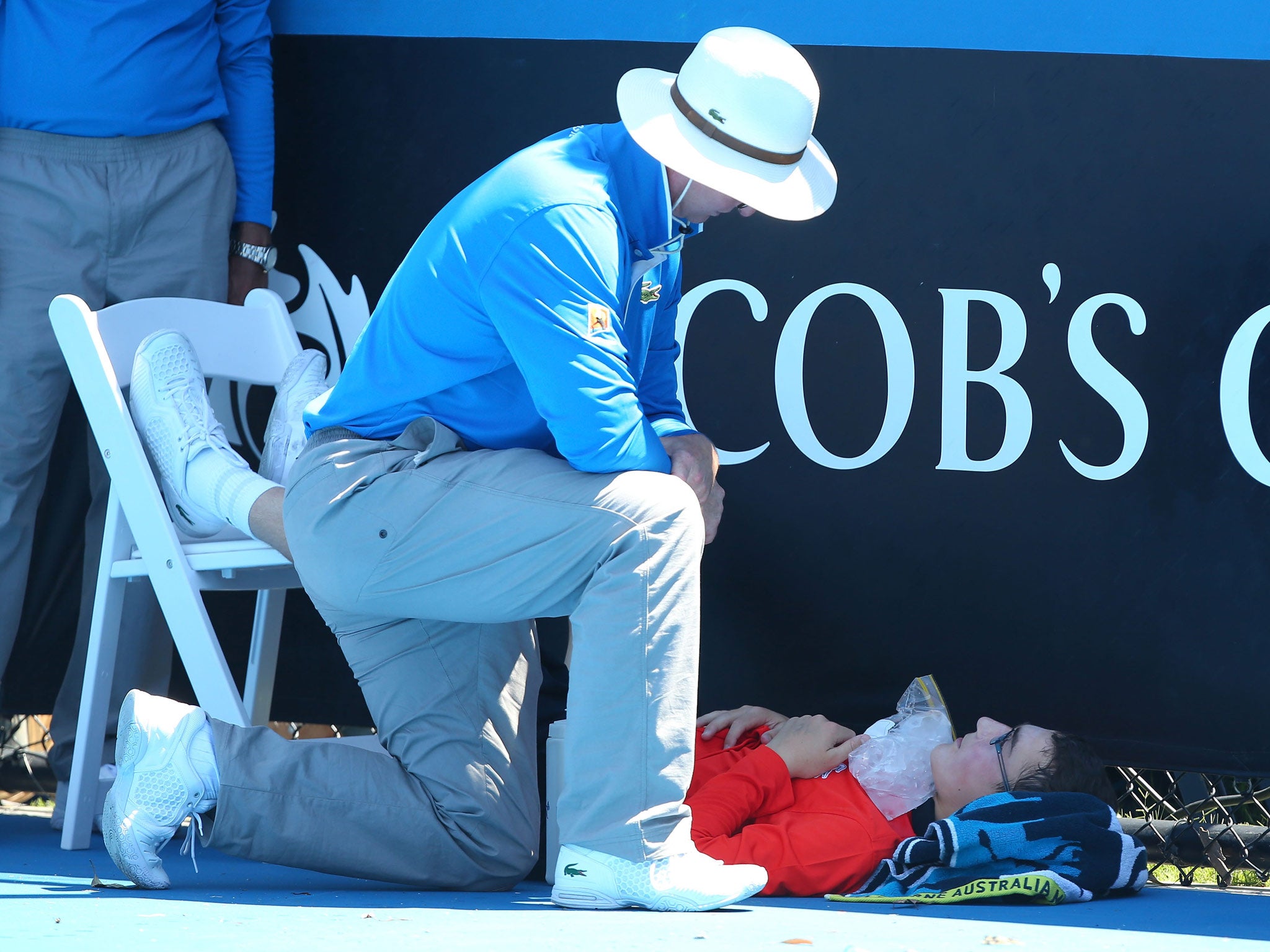 A ballboy faints in the heat, as Melbourne heads towards 43 degrees celsius during day two of the 2014 Australian Open at Melbourne Park