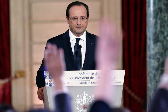Reporters raise their hands during French President Francois Hollande's annual news conference