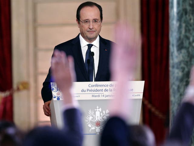Reporters raise their hands during French President Francois Hollande's annual news conference
