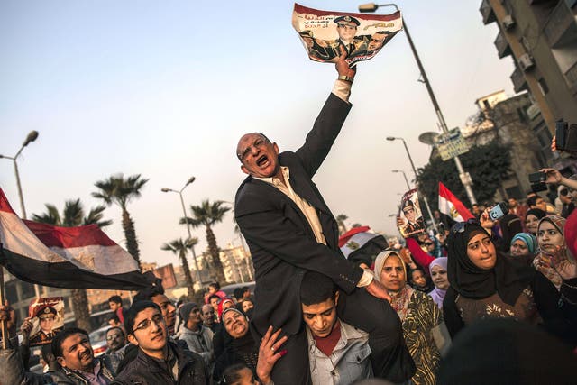 A picture of General Sisi is held aloft at a polling station in Cairo