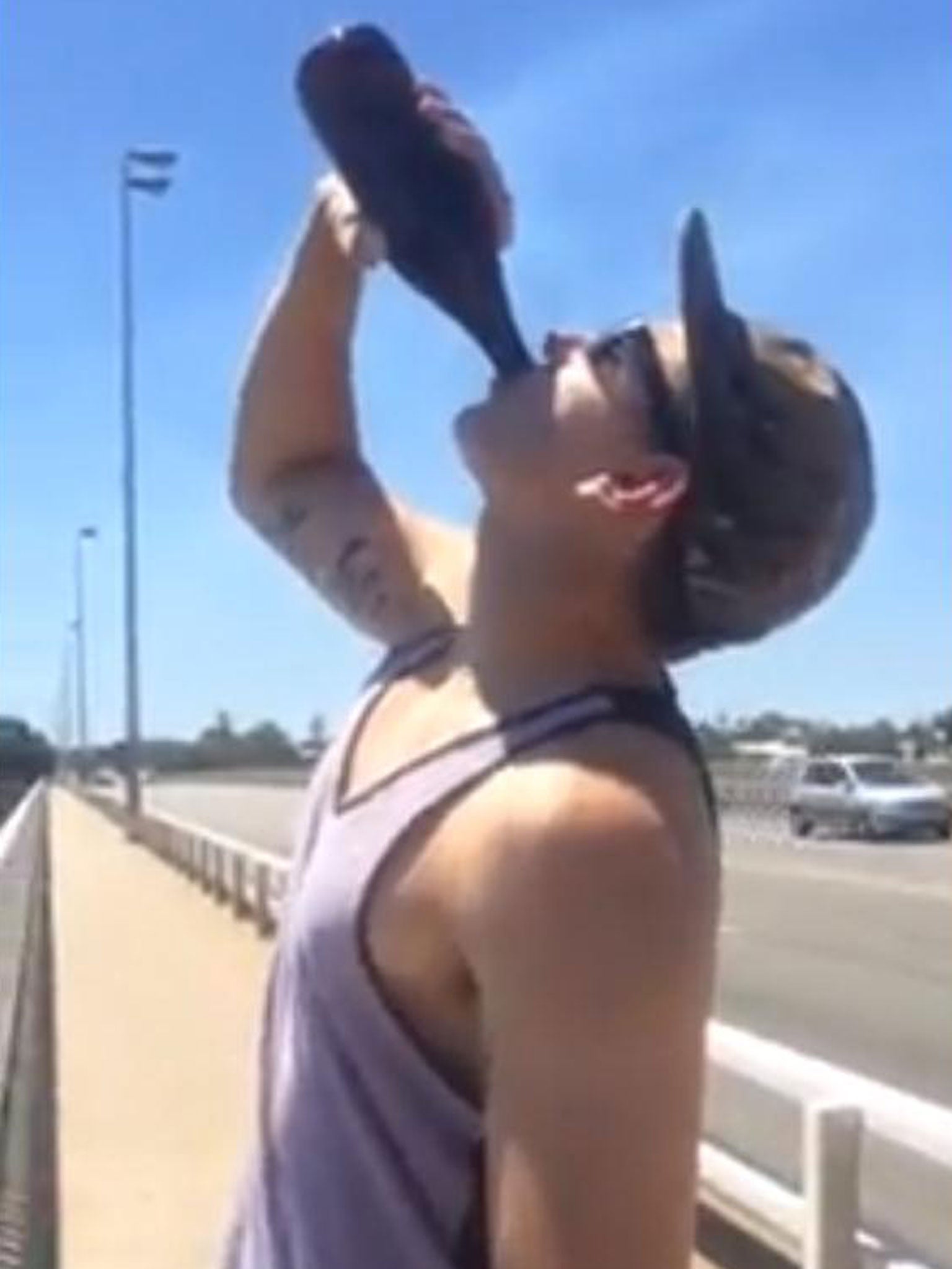 This man drinks before he prepares to jump into the sea