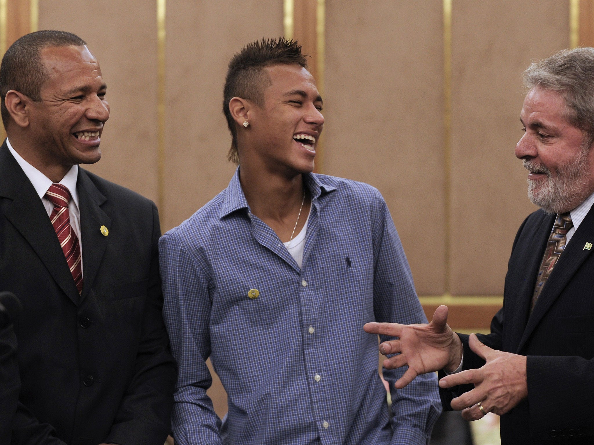 Brazil's President Luiz Inacio Lula da Silva (R) shares a joke with Neymar (C) and his father, also Neymar (L)