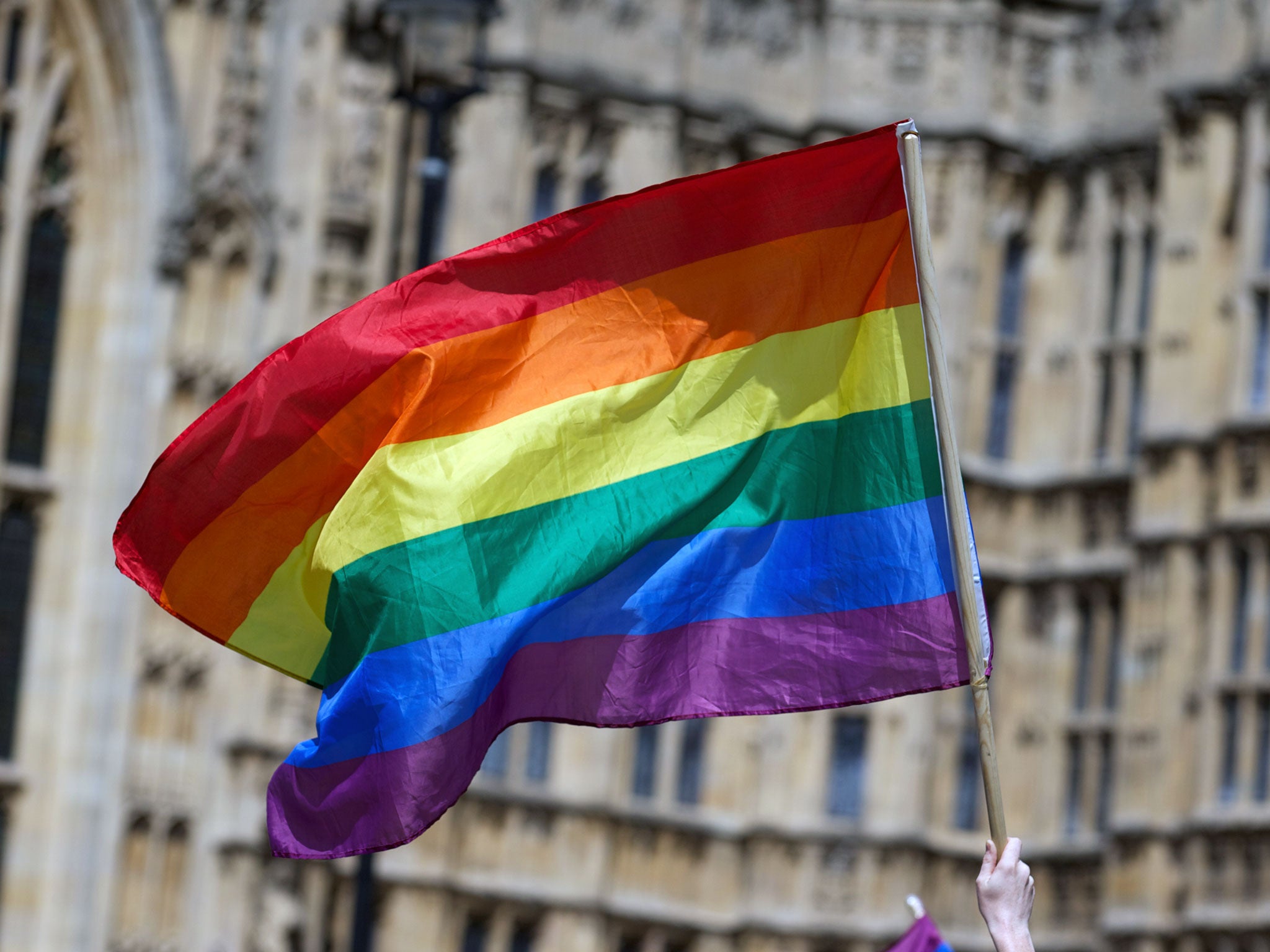 A gay campaigner waves the rainbow flag during a rally outside the Houses of Parliament as the Marriage (Same Sex Couples) Bill gets an unopposed third reading by the Lords in central London on July 15, 2013. Gay marriage was set to be legalised in Englan