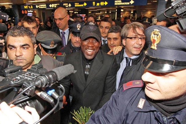 Clarence Seedorf (centre) is mobbed as he arrives at Linate Airport in Milan