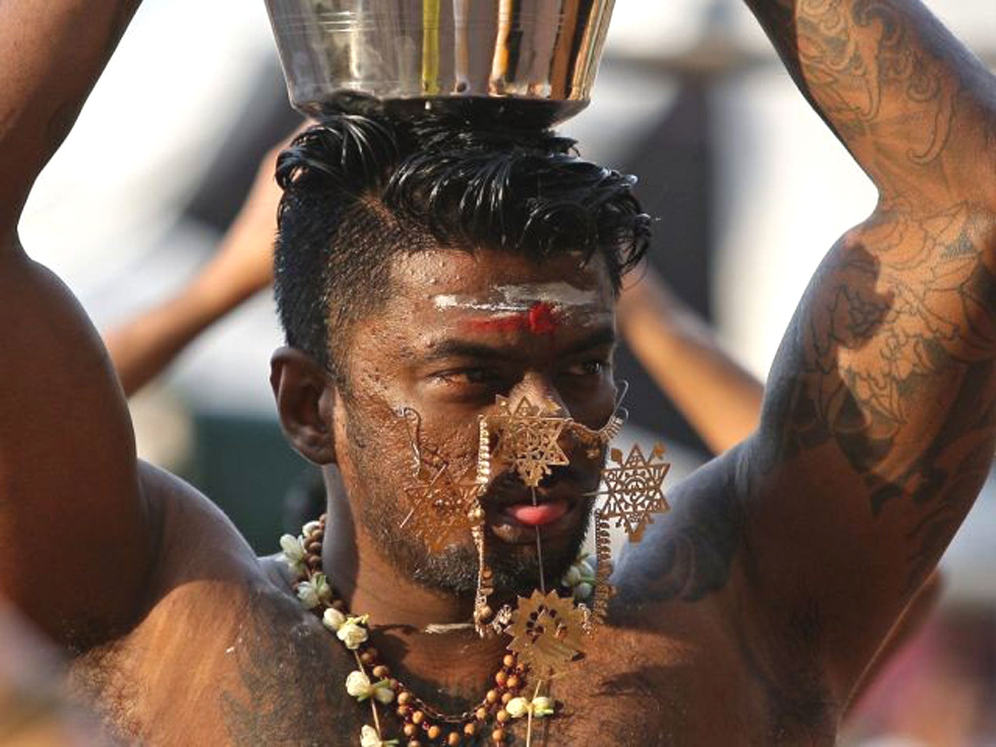 A Hindu devotee with needles protruding his cheeks walks towards the 272 steps taking up to the Batu Caves Temple during the Thaipusam Festival in Kuala Lumpur