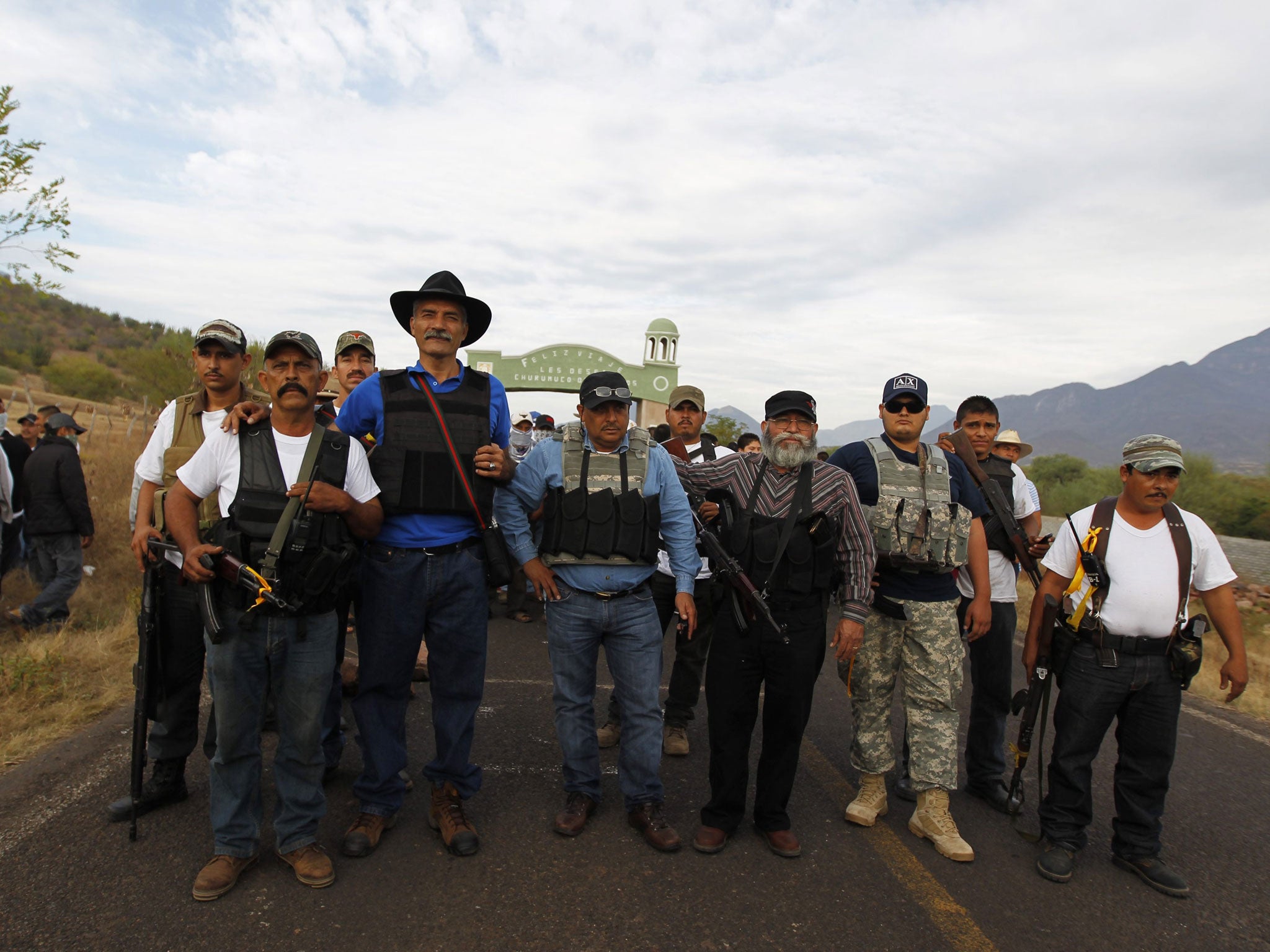 Dr Jose Manuel Mireles (third left), one of the leaders of the Michoacan vigilante group pictured with him. He has since been injured in an aircrash that could have been an attempt on his life