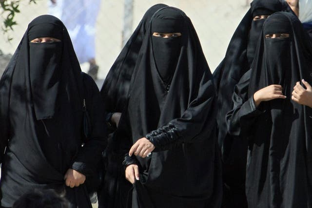 Saudi women cross a street in Hofuf city