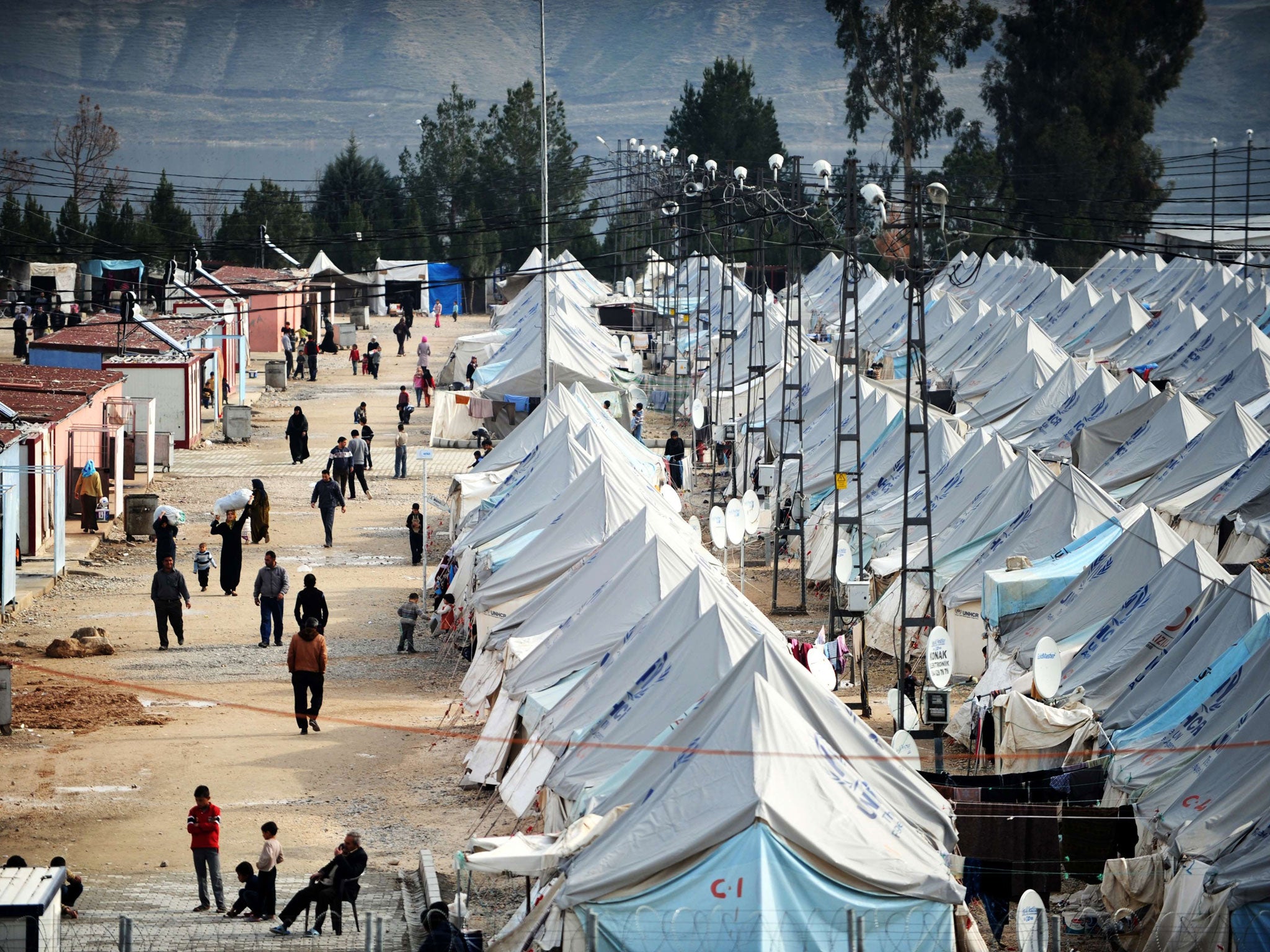 Syrian refugees walk among tents at Karkamis' refugee camp near the town of Gaziantep, south of Turkey