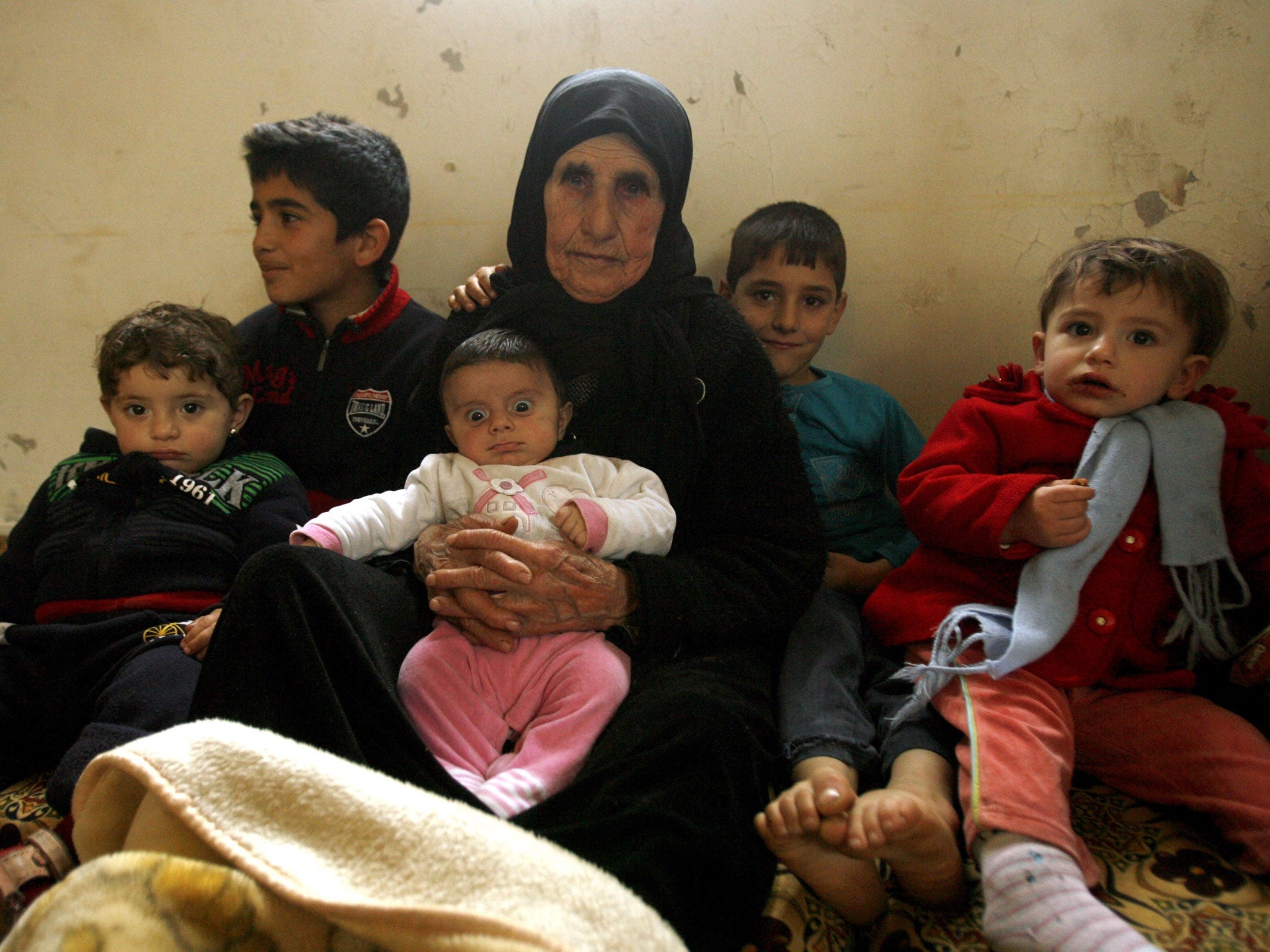 Hallum Al-Amin, a Syrian refugee, sits with members of her family in a house in the village of Qalawayeh, near the southern Lebanese town of Tyre; Amin has just marked her 100th birthday (AFP/Getty Images)