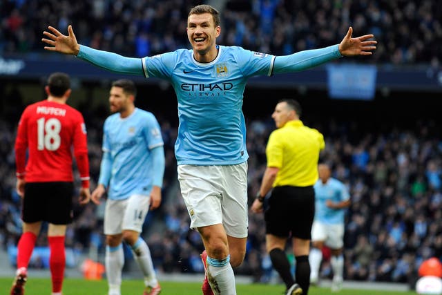 Manchester City striker Edin Dzeko celebrates after scoring their 100th goal of the season in the win over Cardiff
