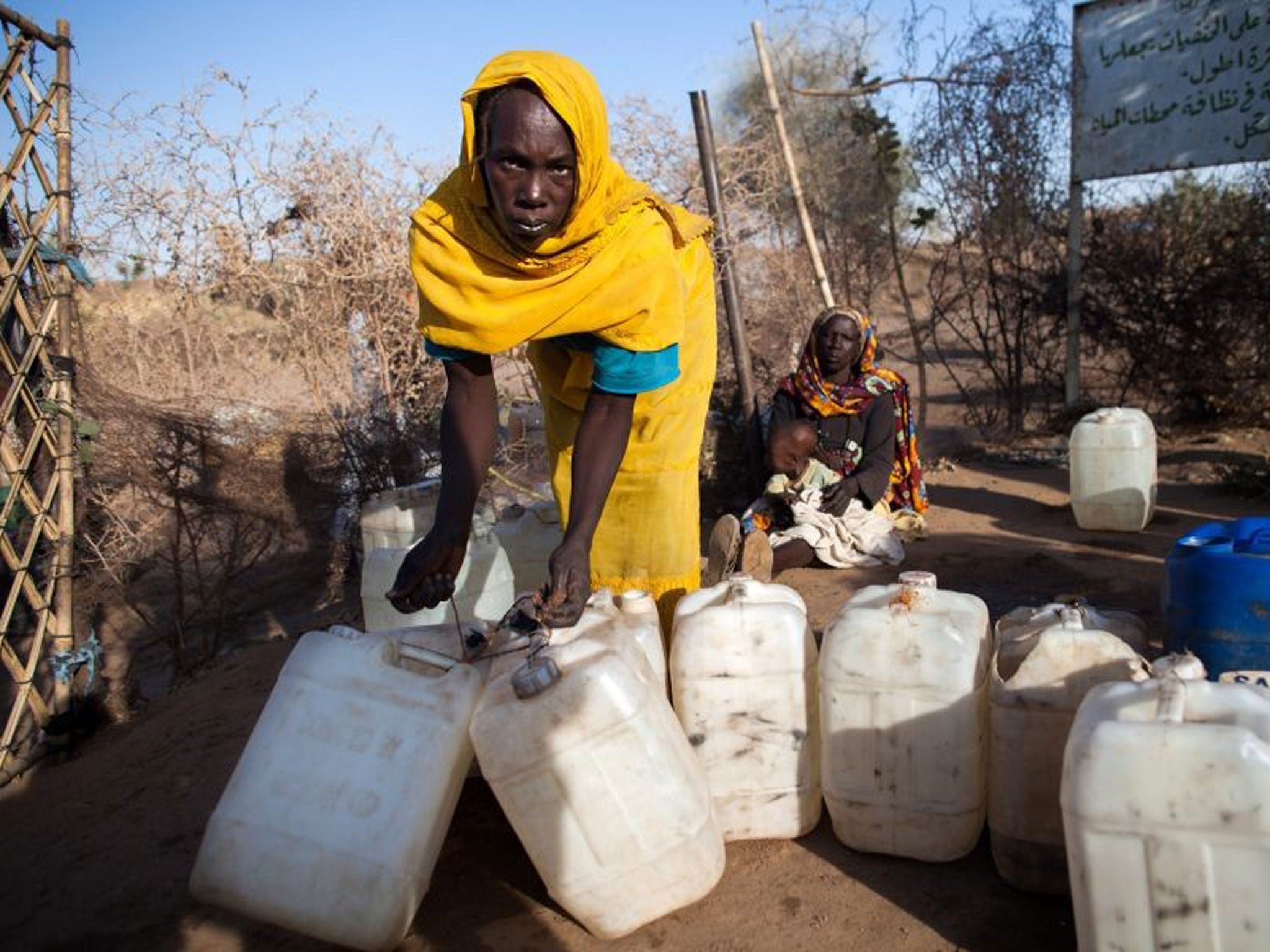 What about Darfur? A woman with empty jerry cans for water leaving a camp for Internally Displaced Persons