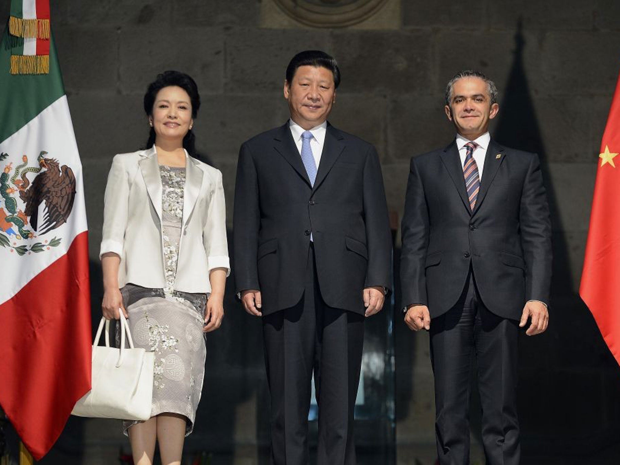 New direction: President Xi Jinping (pictured here with his wife and Mexico City's Mayor Miguel Mancera) is moving China away from state control of the investment process