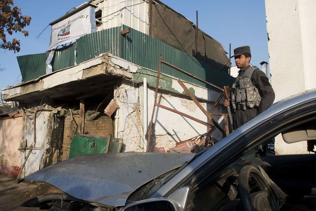 Carnage: A Kabul policeman surveys the damage
