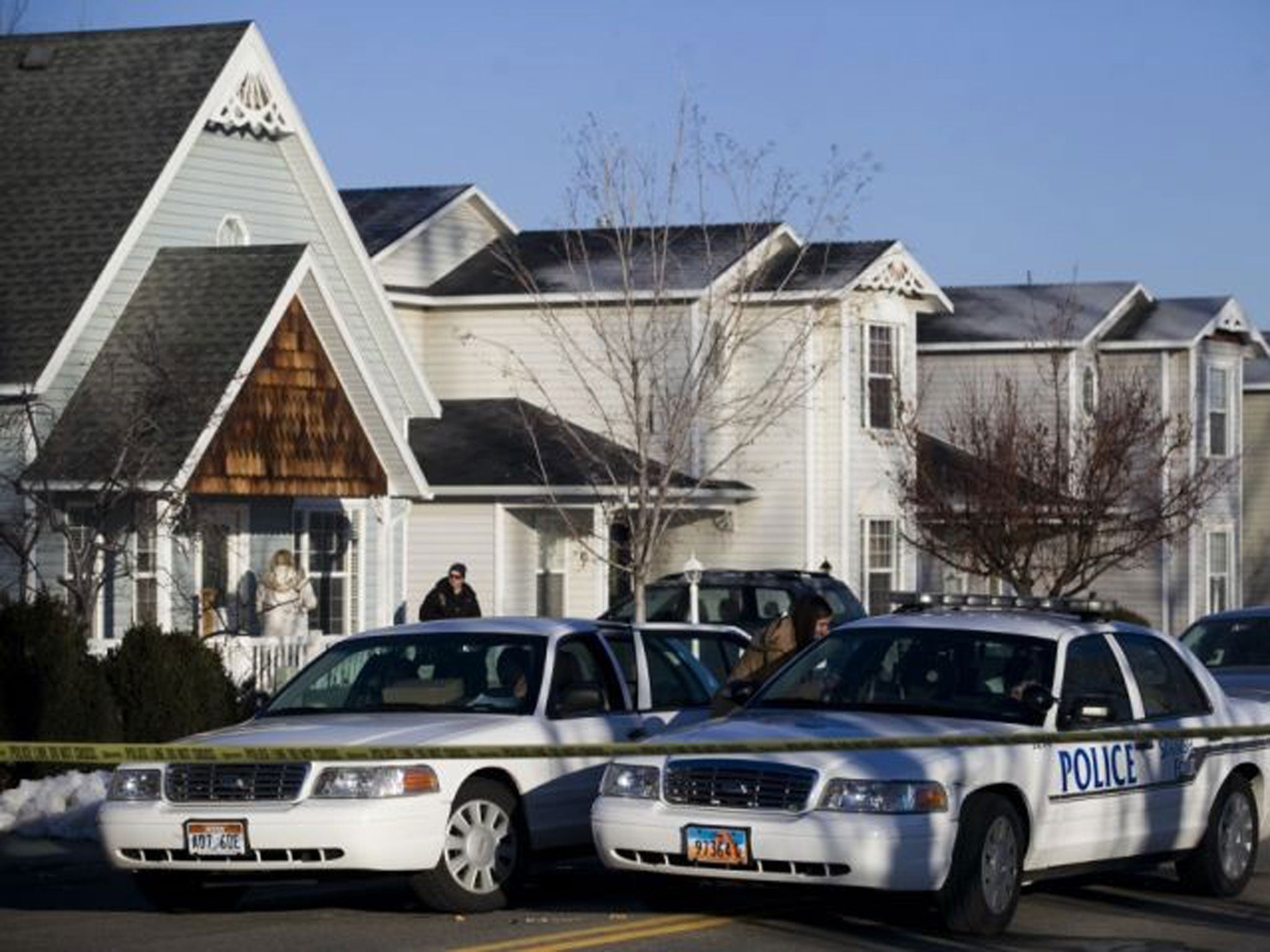 Police gather outside the family home in Spanish Fork, Utah, where the family were murdered on 16 January 2014.