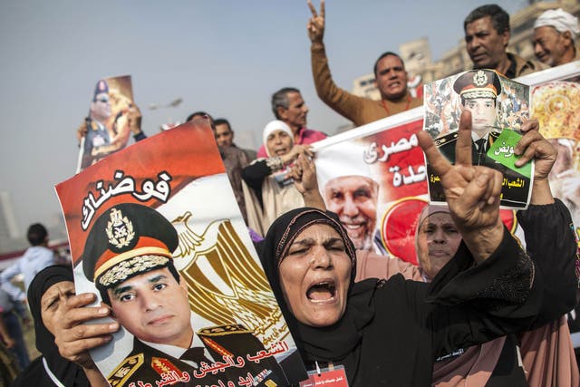 Supporters of Egypt's military chief Abdel Fattah al-Sisi hold his portrait on November 19, 2013