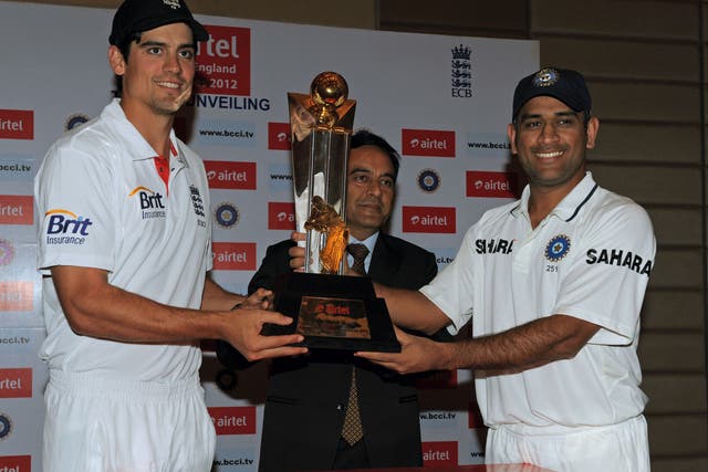 England cricket team captain Alastair Cook (left) and his Indian team counterpart Mahendra Singh Dhoni (right) pose with the championship trophy with Bharti Airtel Gujarat CEO Anant Arora (centre) in Ahmedabad in November 2012