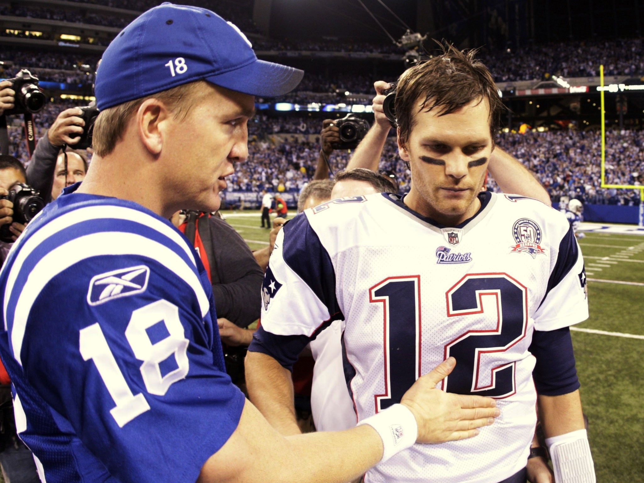 Quarterback Peyton Manning (left) then of the Indianapolis Colts greets Tom Brady (right) of the New England Patriots