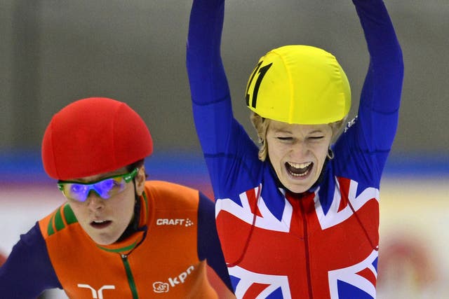 Elise Christie raises her arms in triumph after winning the European 1,000m final