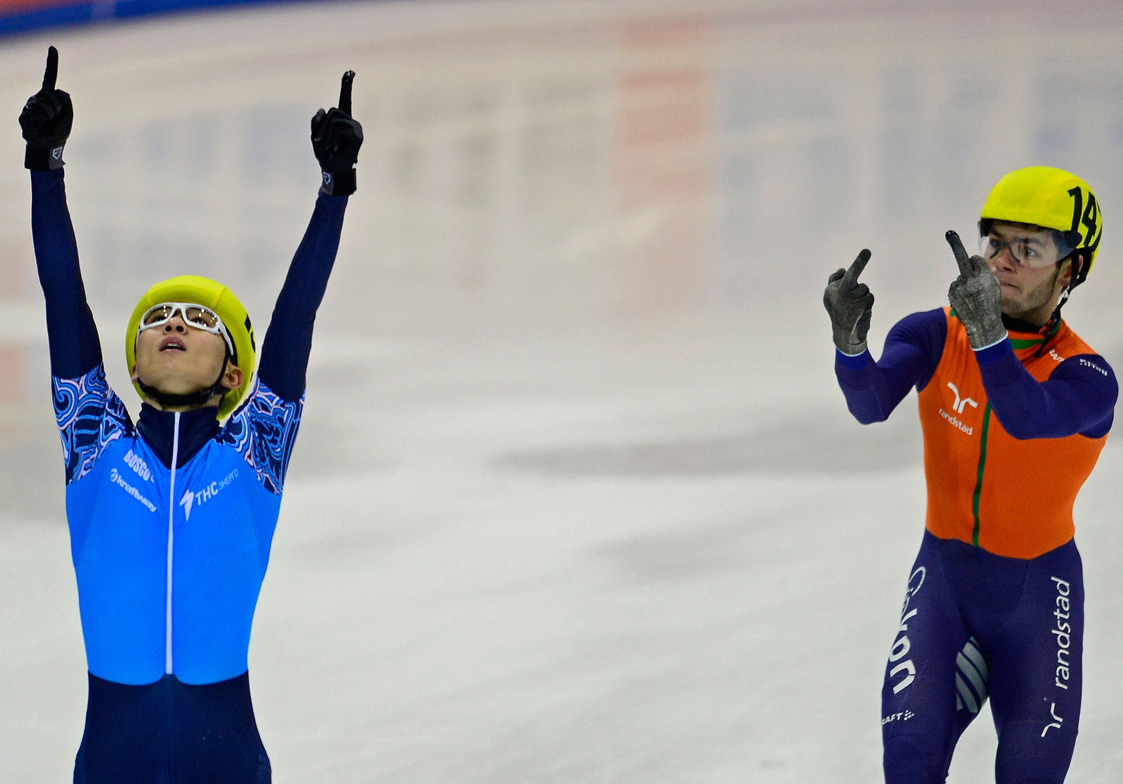 Sjinkie Knegt (R) of the Netherlands' team gestures next to Victor An (L) of the team of Russia celebrating after Russia won the men's 5000m relay final race of the ISU European Short Track speed skating Championships in Dresden, eastern Germany, on Janua