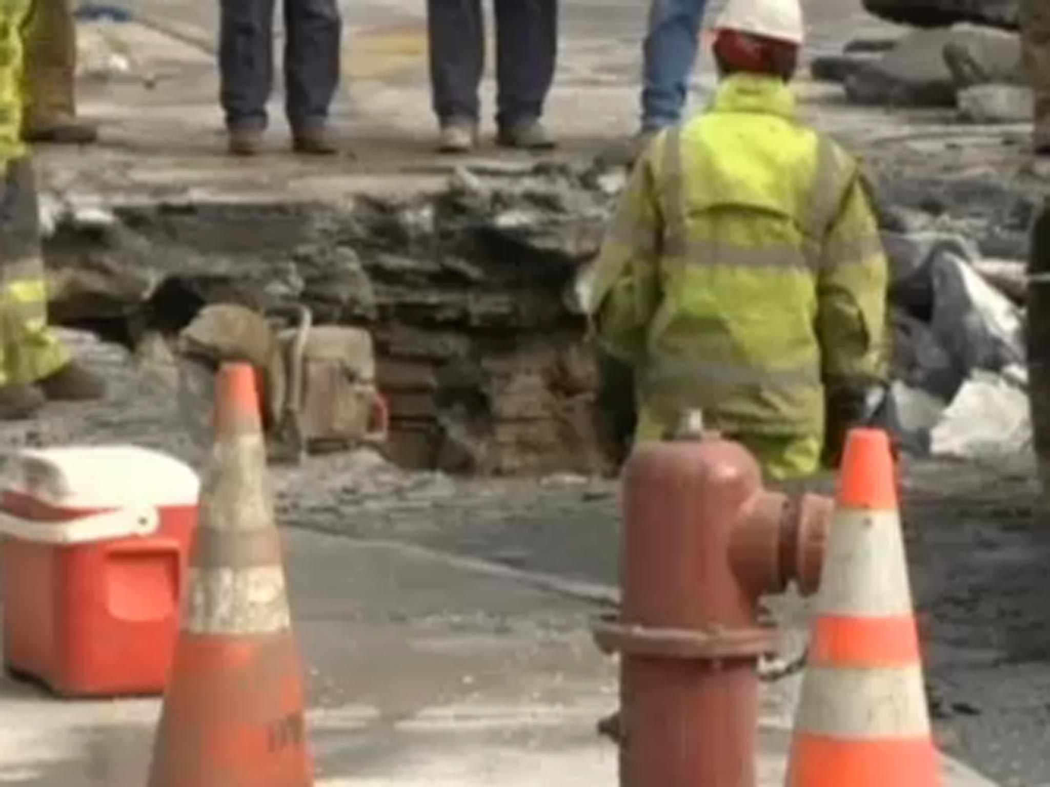 A worker stands in the sinkhole which opened up on a street in downtown Detroit
