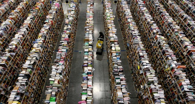 A worker gathers items for delivery from the warehouse floor at Amazon's distribution center in Phoenix, Arizona.