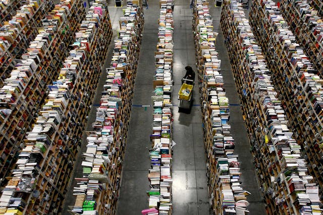 A worker gathers items for delivery from the warehouse floor at Amazon's distribution center in Phoenix, Arizona.
