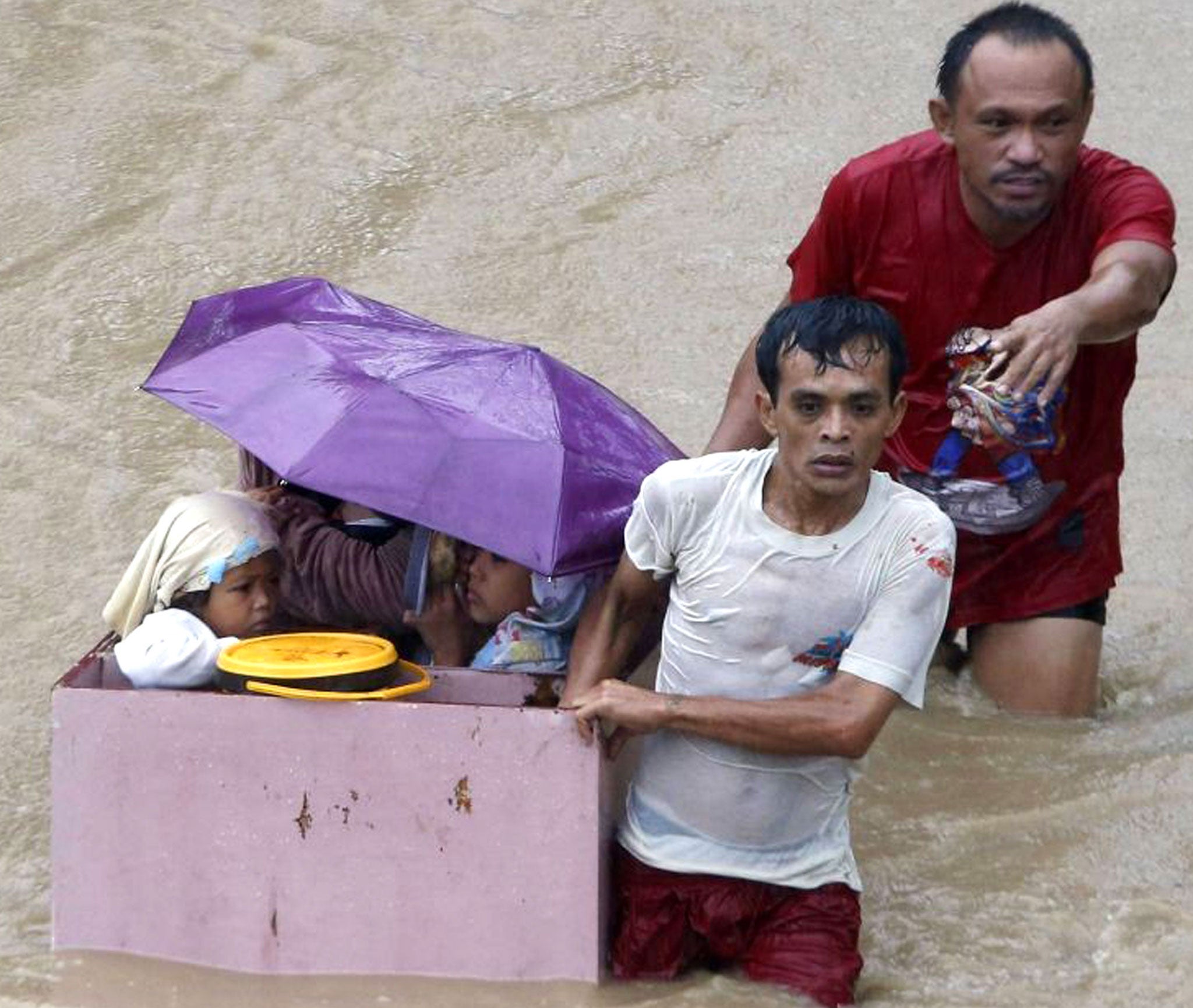 Children ride in a makeshift raft as they are evacuated from flooding brought by tropical depression 'Agaton' in Butuan